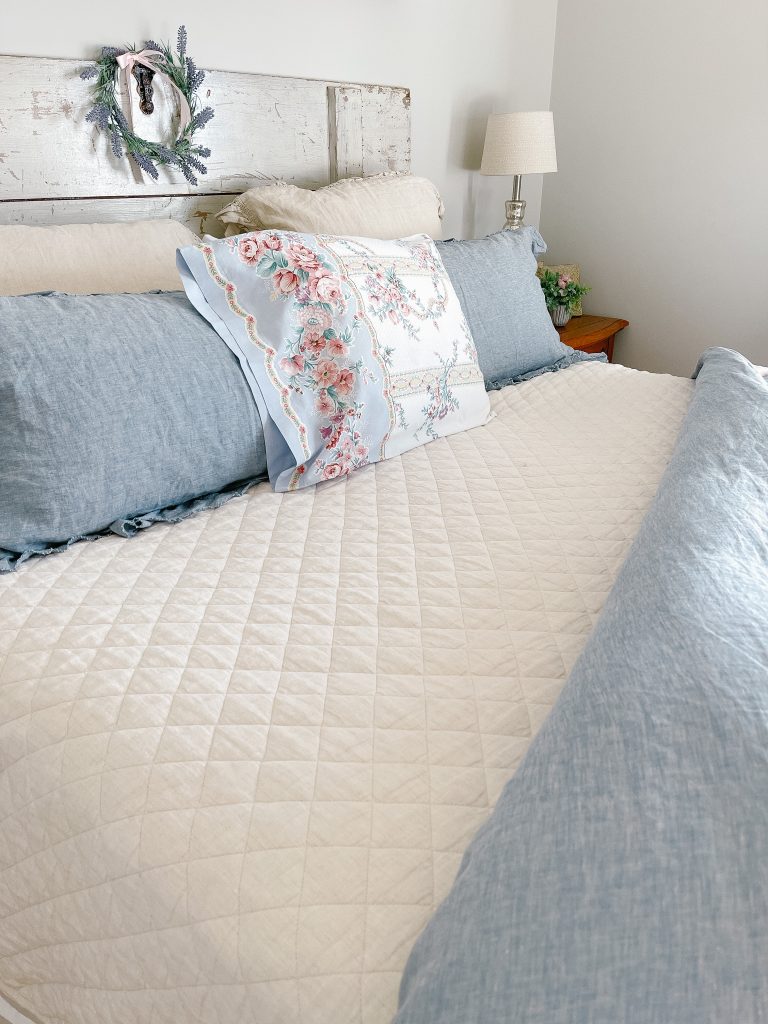 diamond stitch quilt with blue linen bedding layers. 