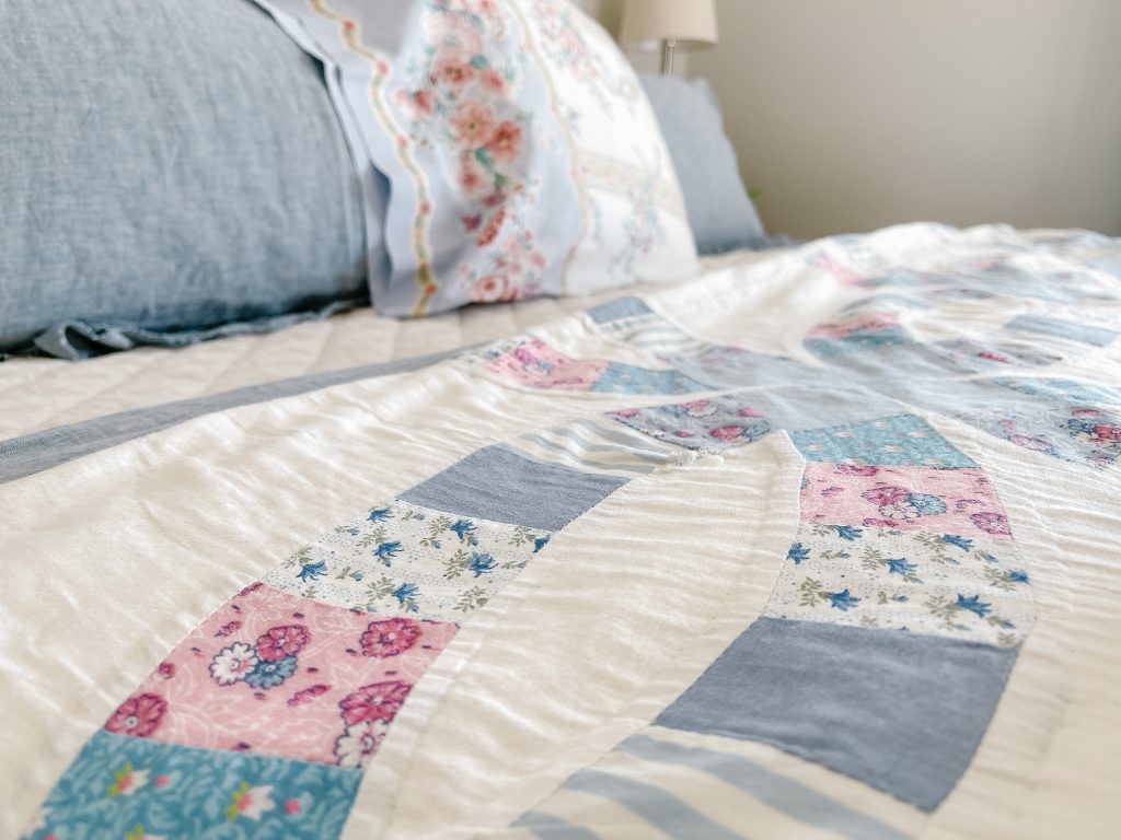 Vintage wedding ring quilt folded across a layered bed